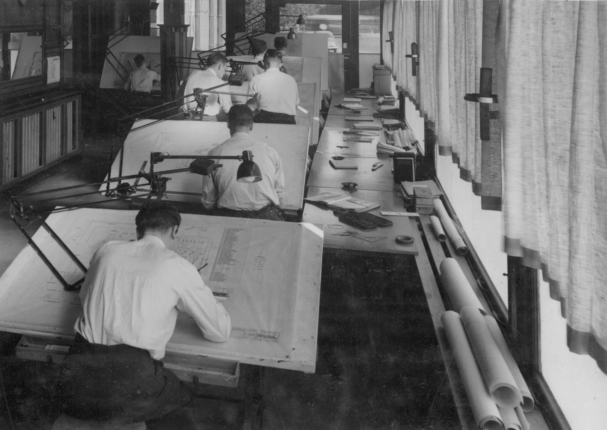 Black and white photo of engineers at drafting tables