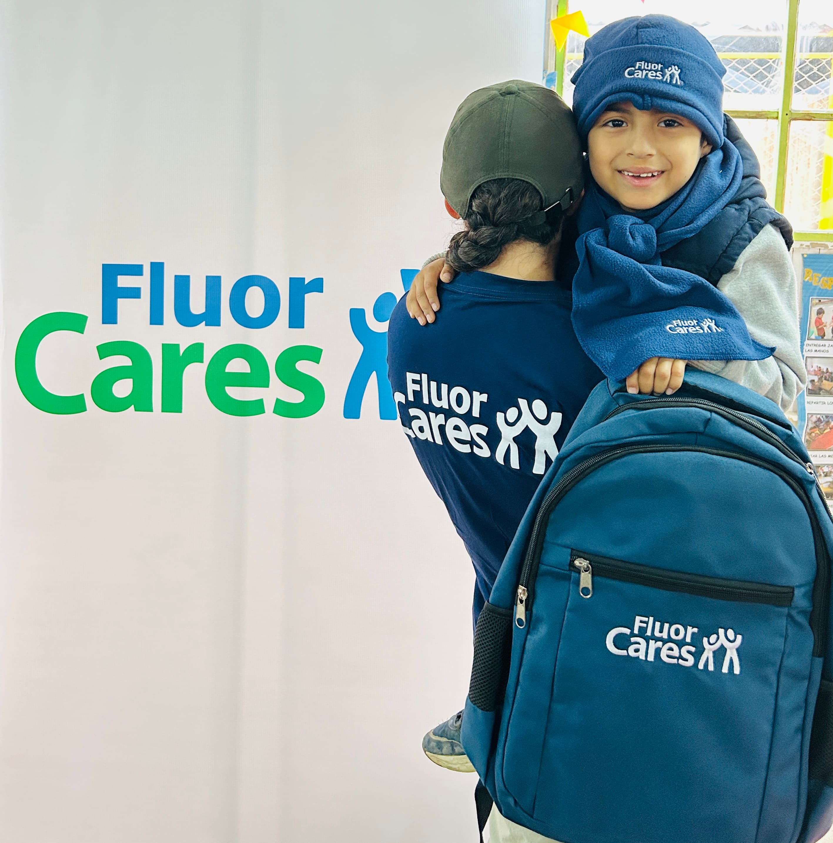 Woman with child holding backpack full of donated school supplies
